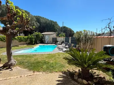 a swimming pool in a yard with a tree at Studio 2 personnes in Vinassan