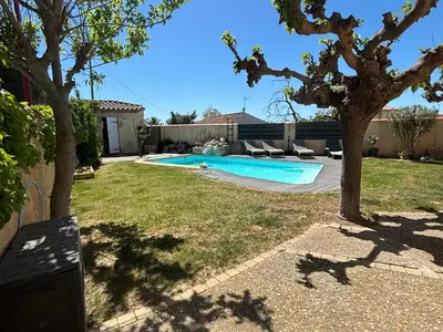 a backyard with a swimming pool and a tree at Studio 2 personnes in Vinassan