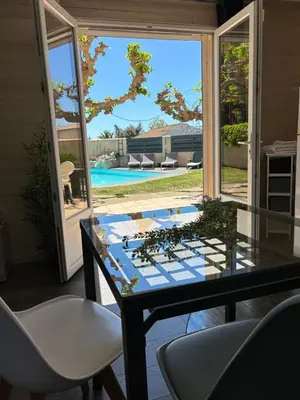 a glass table and chairs in a room with a window at Studio 2 personnes in Vinassan