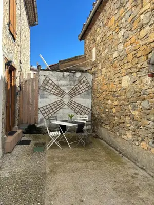 a table and chairs next to a brick wall at Petit Grange Puivert no 26 in Puivert