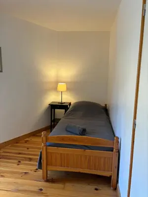 a bedroom with a bed and a table with a lamp at Petit Grange Puivert no 26 in Puivert