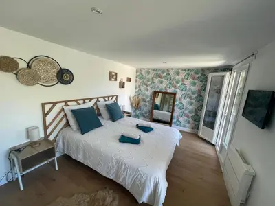 a bedroom with a large white bed with blue pillows at Alba zen & spa in Villefranche-de-Lauragais