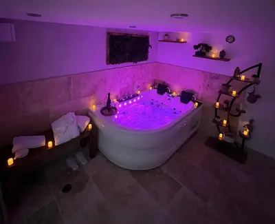 a purple bathroom with a tub with lights in it at Alba zen & spa in Villefranche-de-Lauragais