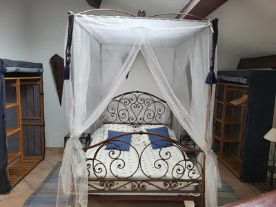 a bed with a canopy in a room at Le Gîte des étoiles de la Clape in Salles-d'Aude