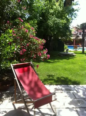 a red chair sitting on a patio in a yard at La Cathare in Lézignan-Corbières