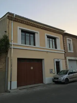 a house with a car parked in front of it at La Cathare in Lézignan-Corbières