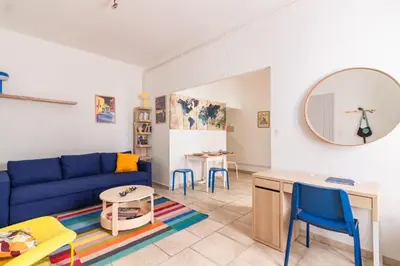 a living room with a blue couch and a table at Le Cerisier des 4 Chemins - Appt 75m² pour 6 in Carcassonne