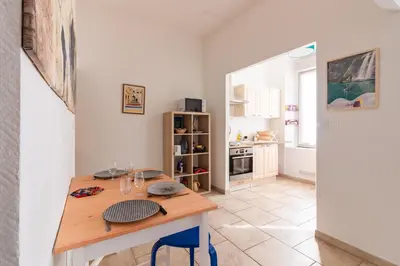 a kitchen with a wooden table in a room at Le Cerisier des 4 Chemins - Appt 75m² pour 6 in Carcassonne