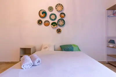 a bedroom with a bed with plates on the wall at Le Cerisier des 4 Chemins - Appt 75m² pour 6 in Carcassonne