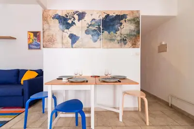 a table with two chairs and a map on the wall at Le Cerisier des 4 Chemins - Appt 75m² pour 6 in Carcassonne