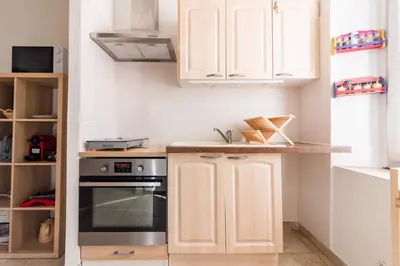 a kitchen with white cabinets and a stove at Le Cerisier des 4 Chemins - Appt 75m² pour 6 in Carcassonne