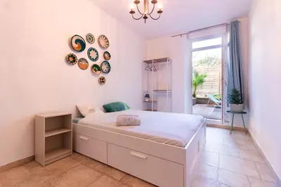 a white bedroom with a bed and a window at Le Cerisier des 4 Chemins - Appt 75m² pour 6 in Carcassonne