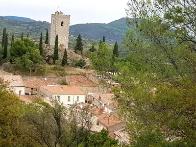 a village with a clock tower in the distance at La Loubière - Gîte in Cessenon
