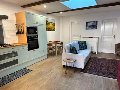a living room with a couch and a kitchen at La Loubière - Gîte in Cessenon