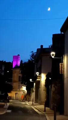 a city street with a pink tower in the background at La Loubière - Gîte in Cessenon