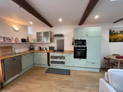 a kitchen with white cabinets and a counter top at La Loubière - Gîte in Cessenon