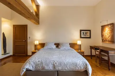 a bedroom with a large bed and a desk at Grande Maison de Charme a 5 mn du centre ville in Narbonne