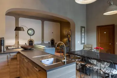 a kitchen with a sink and a counter with chairs at Grande Maison de Charme a 5 mn du centre ville in Narbonne