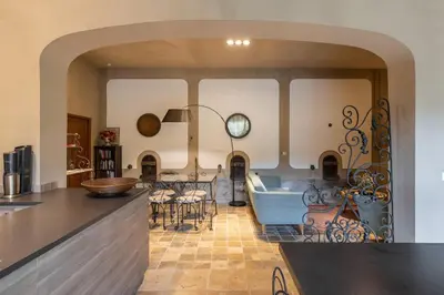 a kitchen and a living room with a table at Grande Maison de Charme a 5 mn du centre ville in Narbonne