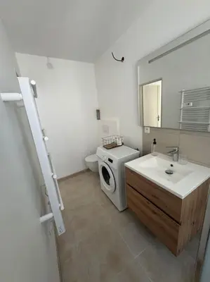 a bathroom with a sink and a washing machine at Appartement centre historique in Narbonne