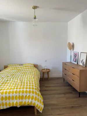 a bedroom with a yellow bed and a wooden dresser at Appartement centre historique in Narbonne