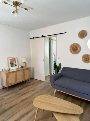 a living room with a blue couch and a table at Appartement centre historique in Narbonne