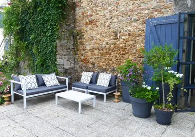 three chairs and a table on a patio with plants at Domaine de la laugerie - relais du consul in Castres