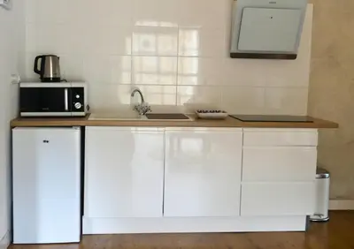 a kitchen with white cabinets and a microwave at Domaine de la laugerie - relais du consul in Castres
