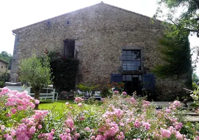 an old stone house with flowers in front of it at Domaine de la laugerie - relais du consul in Castres