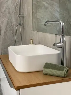 a white sink on a wooden shelf in a bathroom at Dame Carcas in Carcassonne