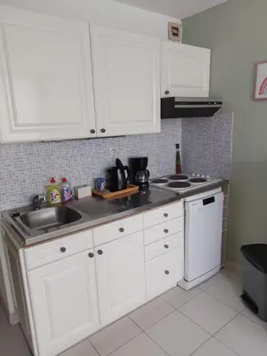 a kitchen with white cabinets and a sink at Vagues et Vignes Gruissan Appt T2 bien placé tout équipé WIFI avec parking privé in Gruissan