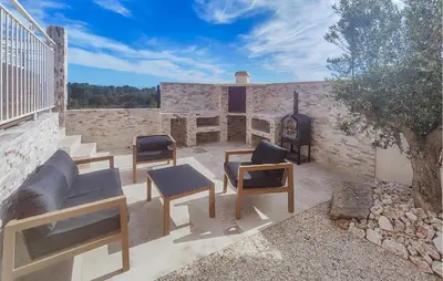 a patio with chairs and a grill on a building at Lovely Home In Villespassans With Wifi in Villespassans