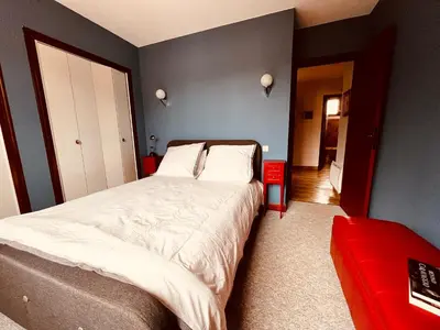 a bedroom with a large bed and a red couch at Apartment with views in Limoux