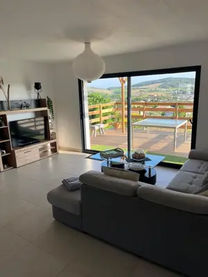a living room with a couch and a large window at Les pontils in Limoux