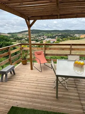 a wooden deck with a table and chairs on it at Les pontils in Limoux