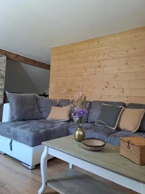 a living room with a blue couch and a table at Maison vue sur lac en moyenne montagne in Pradelles-Cabardès