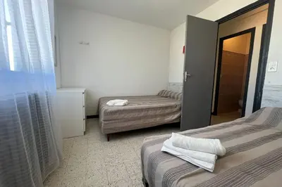 a small room with two beds and a window at Spacious nest with sea view in Port-la-Nouvelle