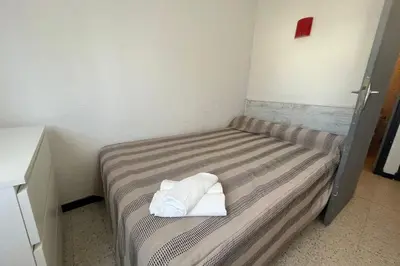 a bed with two towels on it in a room at Spacious nest with sea view in Port-la-Nouvelle