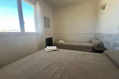 a room with two beds and a window at Spacious nest with sea view in Port-la-Nouvelle