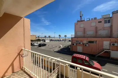 a balcony with a red car parked in a parking lot at Spacious nest with sea view in Port-la-Nouvelle