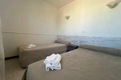 a room with two beds with towels on them at Spacious nest with sea view in Port-la-Nouvelle