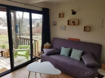a living room with a purple couch and a balcony at Chaleureux Chalet Lac Roussinas in Anglès