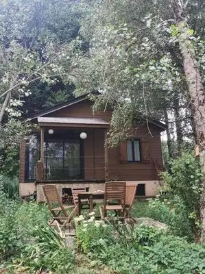 a cabin with a table and chairs in front of it at Chaleureux Chalet Lac Roussinas in Anglès