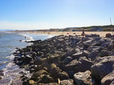 a group of people on a beach with rocks at Holiday Home La maison du carignan by Interhome in Armissan