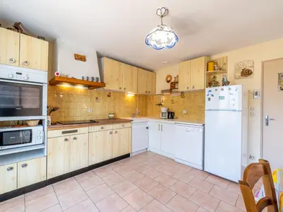 a kitchen with white appliances and wooden cabinets at Holiday Home La maison du carignan by Interhome in Armissan