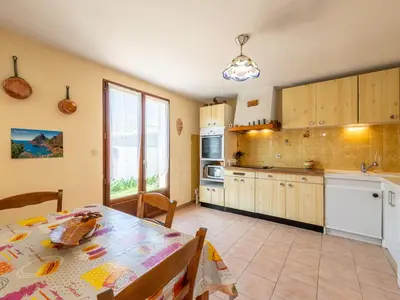 a kitchen with a table and a dining room at Holiday Home La maison du carignan by Interhome in Armissan