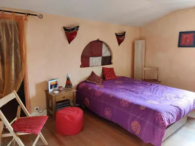 a bedroom with a purple bed and a table and a chair at Chambre d'hôte chez l'habitant à la campagne in Cambounet-sur-le-Sor