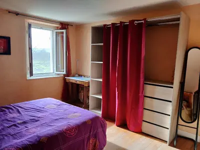 a bedroom with a bed with red curtains and a window at Chambre d'hôte chez l'habitant à la campagne in Cambounet-sur-le-Sor