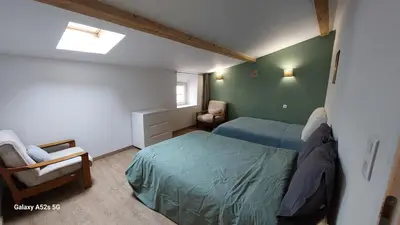 a small bedroom with two beds and a chair at Le duplex sigeannais in Sigean