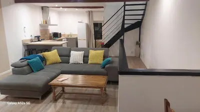 a living room with a couch and a table at Le duplex sigeannais in Sigean